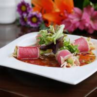 Tuna On The Beach · Spicy crab meat and avocado wrapped with Sliced seared tuna, served with House made onion dr...