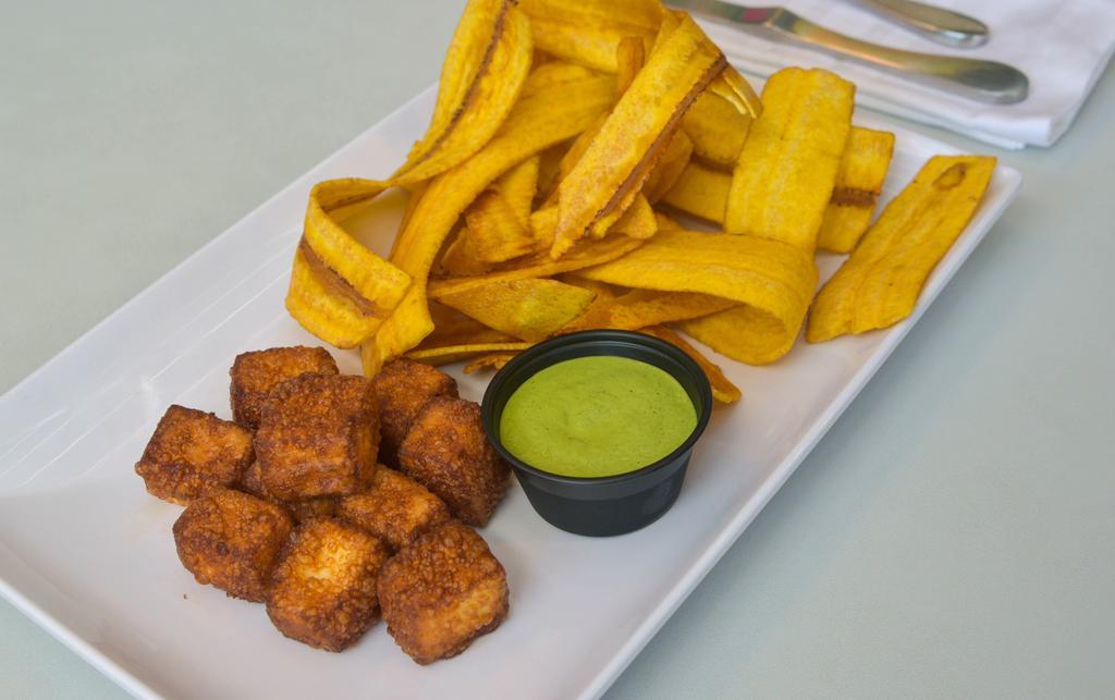 Queso Frito · Fried cheese cubes with fried green plantain chips and homemade cilantro sauce.