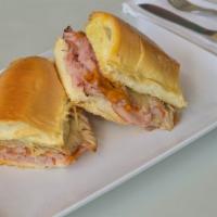 Sarussi Original Sandwich · Smoked ham, roasted pork leg, mozzarella cheese, pickles, and house sauce.