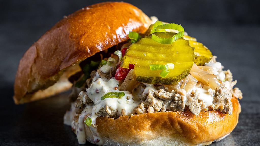Da Clucker · Smoked chopped chicken, Alabama white BBQ sauce, caramelized onions, and B&B pickles.
