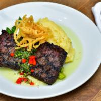 Churrasco Steak · 8 oz grilled marinated chairman's reserve skirt steak topped with crispy onion strings, serv...