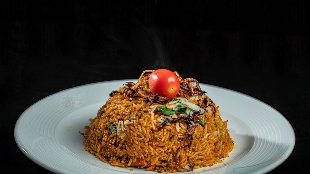 Chicken Biryani · Tender pieces of chicken cooked with our homemade spice and then layered with aromatic basmati rice, gently flavored with saffron and nuts.