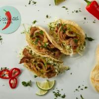 Carne Asada Tacos · Three tacos filled with beef, white cabbage, onions, chimichurri, cilantro, and lime.