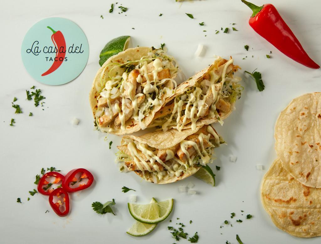 Pollo Asado Tacos · Three tacos filled with grilled chicken, white cabbage, onions, chimichurri, and wasabi mayonnaise.