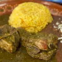 Costilla De Puerco En Salsa Verde///Pork In Green Sauce · Chunks of pork shoulder, slow cooked in a green chili sauce served with rice and refried bea...