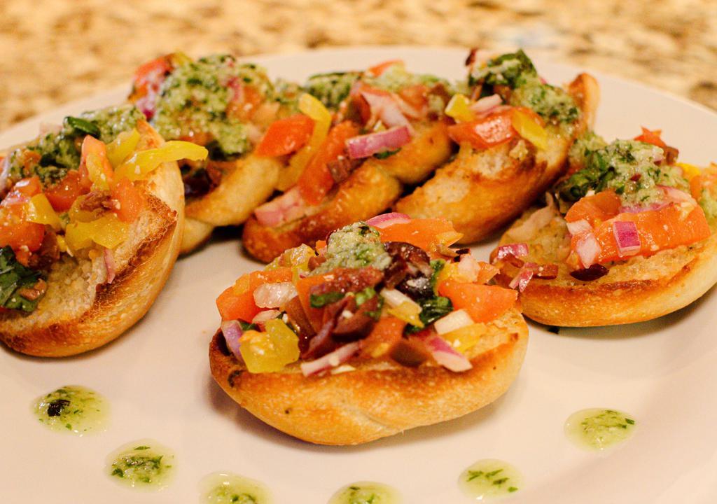 Bruschetta · chopped tomatoes, Red onion, banana pepper, olives, fresh basil mix, served on homemade garlic and Parmesan bread
