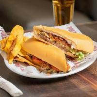 Pan Con Bistec Especial · Special Steak sandwich topped with ham, cheese, grilled onions, lettuce, tomatoes  and papit...