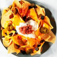 Macho Nachos · Corn tortilla chips, beans, and melted cheeses, topped with sour cream and salsa.