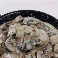 Champis Con Cabrales · Sliced mushrooms sautéed with garlic and sprinkled with aged blue cheese.