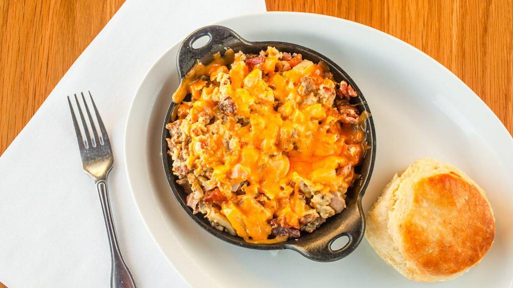 Bbb Skillet · Three scrambled eggs, bacon, sausage, ham, onions, potatoes, and cheddar. Served with your choice of toast or biscuit.