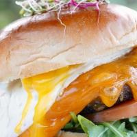 Sagrado Burger · Juicy beef patty, brioche bun, Cheddar, tomatoes, arugula & egg sunny-side-up. Served with f...