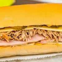 Our Famous Cuban Sandwich · Serrano ham, Roast Pork, Pulled Pork, Kosher Pickles, and Mustard smothered in Melted German...
