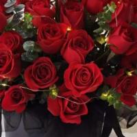 Signature Red Rose Box · 24 signature red color roses with eucalyptus and similar color filler flowers in a flower box.