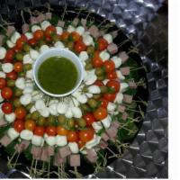 Caprese Salad · Sliced tomatoes, fresh mozzarella, black olives, and basil.