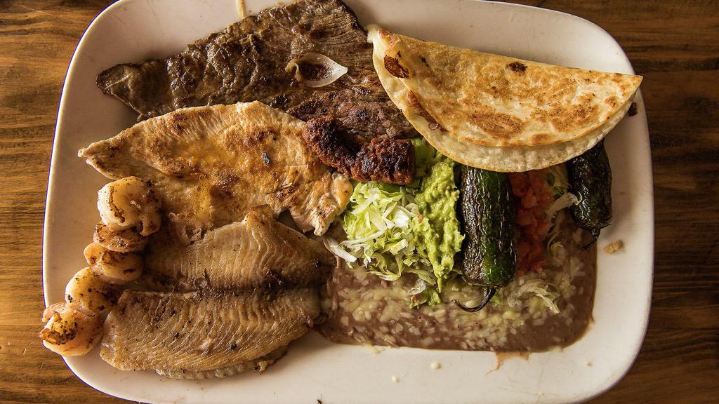 Parrillada Osvaldo · Combination of tender, thinly-sliced steak, chicken breast, shrimp, fish fillet and chorizo all prepared with our chef’s special marinade, then grilled to perfection. Served with rice and beans, cheese quesadilla, slice of tomato, avocado slice and jalapeños.
