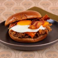 Breakfast Fried Chicken Sandwich · Crispy fried chicken thighs with crispy bacon, melted cheddar cheese, and a fried egg on a b...