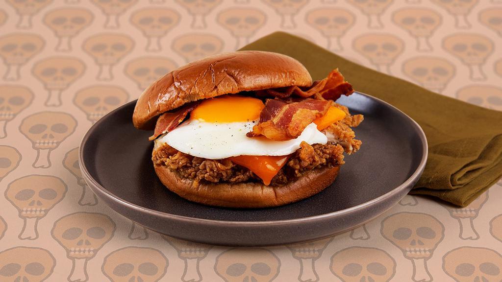Breakfast Fried Chicken Sandwich · Crispy fried chicken breast with crispy bacon, melted cheddar cheese, and a fried egg on a buttery brioche bun.