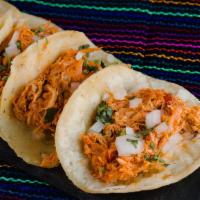 Shredded Chicken Tinga Taco · A taco filled with shredded chicken tinga, lettuce, tomatoes, cheese and sauce.
