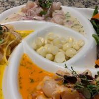 Trilogia De Ceviches Fish · Classic yellow pepper and rocoto fish ceviche with sweet potatoes and Peruvian corn seafood.