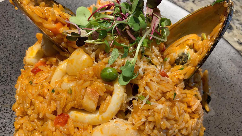 Arroz  Con Mariscos · Traditional Peruvian style paella with shrimps ,calamari ,octopus ,mussels ,scallops ,peas carrots ,red pepper and cilantro in our salsa Madre sauce ,topped with salsa criolla