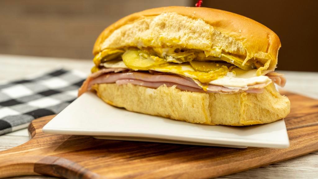 Sandwich Media Noche / Midnight Sandwich · Jamón, queso, cerdo, mayonesa, mostaza y pepinillos. / Ham, cheese, pork, mayonnaise, mustard, and pickle