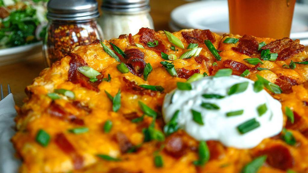 Pizza Skins · Roasted Garlic Mashed Potatoes, Cheddar Cheese, Applewood Smoked Bacon, Scallions, and Sour Cream.