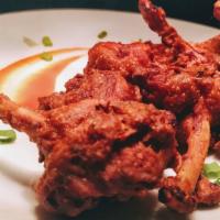Chicken Lollipop · Chicken lollipop in red southern spices, deep fried and topped with curry leaves and lemon.