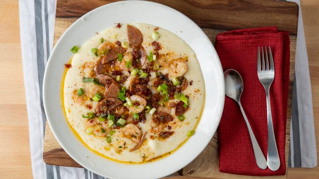 Shrimp & Grits · Sautéed shrimp with bacon, andouille sausage, garlic, and Tabasco over white cheddar Parmesan cheese grits.