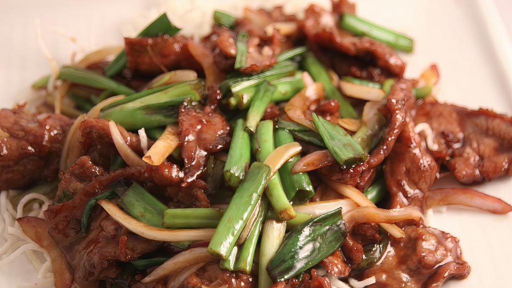 Mongolian Beef · Thinly sliced beef with garlic, scallions and red onions, served over crispy white rice noodles.