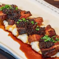 Crispy Braised Pork Belly · Served over Creamy Local Grits with Sorghum & Mustard Glaze.