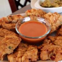 Conch Fritters · Thin slices of conch, combined in a mixture of flour and seasoned batter.
