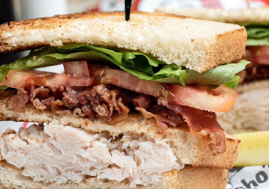 Bacon & Turkey Club · A large serving of fresh sliced turkey breast and strips of crisp bacon, lettuce, and tomato.  On your choice of bread, served with chips and dill pickle spear.