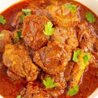 18 Goat Curry · Goat meat cooked slowly in a gravy with onion, tomato, ginger garlic, Indian spices and serv...