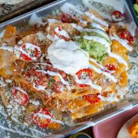 Famous Ultimate Nachos · Oaxaca, manchego and cotija cheese, pickled jalapeños, refried beans, pico de gallo, guacamo...