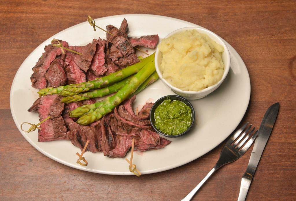 Skirt Steak · Topped with melted blue cheese accompanied by roasted garlic mashed potatoes and grilled asparagus.