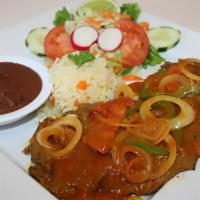 9- Bistec Encebollado / Stewed Meat · With rice and fresh salad and two tortillas.