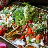 Barbacoa Nachos · Crispy chips, melted cheese, slow-braised barbacoa, house queso, lettuce, jalapenos, sour cr...