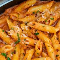 Penne Alla Vodka · Penne pasta served with creamy pink sauce, onions and ham.