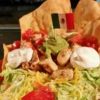 Carlos' Wild Tostada · Beef or chicken, refried beans and cheese, piled high on a giant flour tortilla topped off w...
