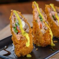 Coquitos Crunch · Salmon tempura crunchy cones stuffed with kani, cream cheese and scallions. Topped with curr...
