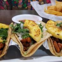 Tacos Al Pastor · New. Three corn tortillas filled mth marinated pork, grilled pineapple, and chopped onions a...