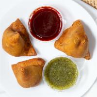 Samosa Trio · A plate of 3 flaky & crispy pastries filled with spiced potatoes & green peas.