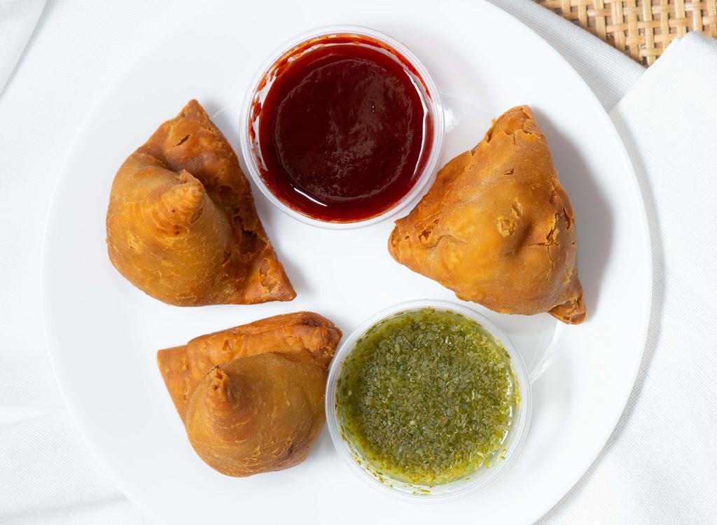 Samosa Trio · A plate of 3 flaky & crispy pastries filled with spiced potatoes & green peas.