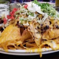 Loaded Tri Colored Nachos Chips · BBQ Pulled Pork or Chicken, Caramelized Onions, Cheddar Jack Cheese, Sour Cream.