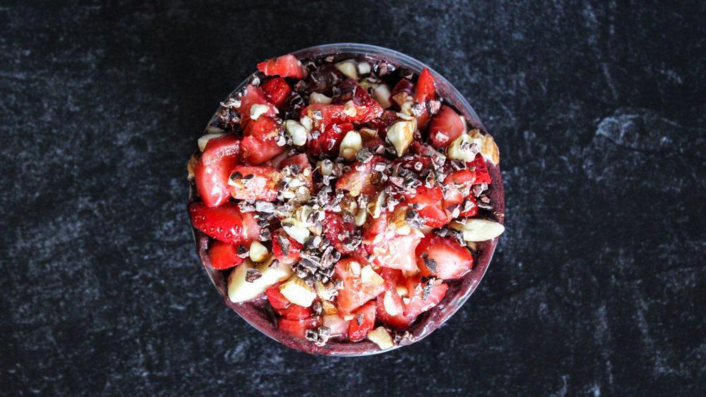 Bombom Bowl · Base: açaí, cacao powder. Toppings: granola, banana, strawberries, almonds, cacao nibs, local honey. Recommended add-on: natural peanut butter.