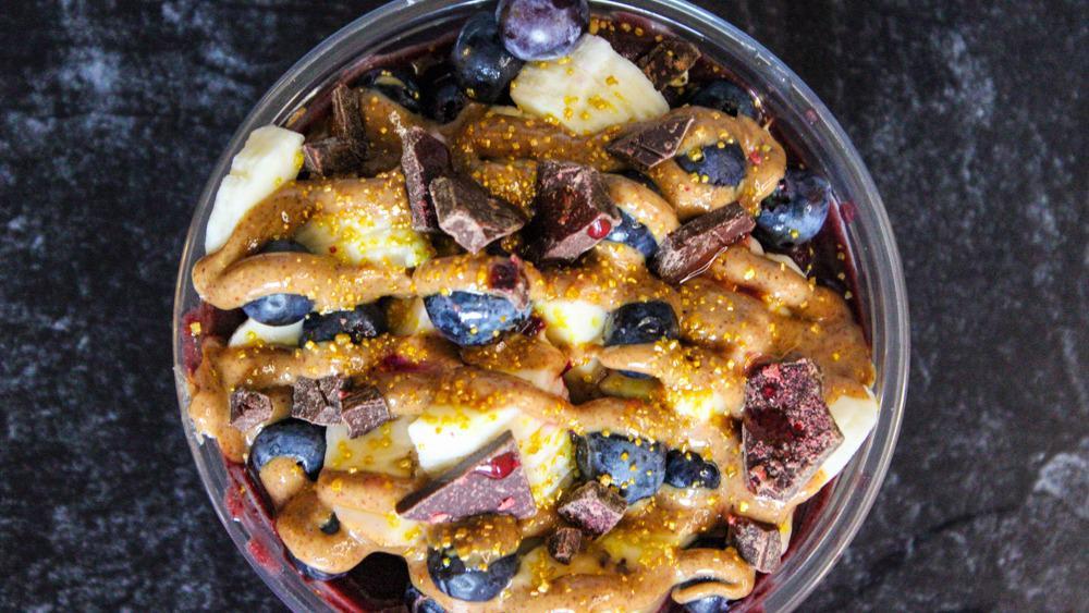 Lotus Bowl · Base: açai, granola. Toppings: banana, blueberries, almond butter, dark chocolate, and dragon fruit infused honey.