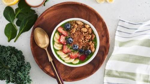 Greens Bowl · Superfoods spinach, kale, pineapple, and banana, with lemon, apple juice, with a coconut milk base. Topped with granola, almond butter, strawberries, blueberries, bananas, hemp seeds, and local honey.