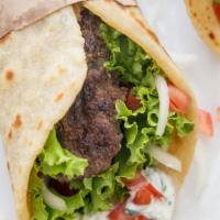 Gyros · Grilled lamb meat with sauteed onions and green peppers  on pita bread, drizzled with tzatzi...