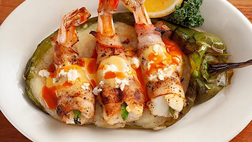 Bacon-Wrapped Stuffed Shrimp · Fire-grilled shrimp, wrapped in hickory smoked bacon and stuffed with fresh jalapeño. Served on top of an Anaheim pepper with Cholula, Queso Fresco and Chile con Queso.