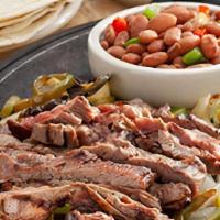 Steak Fajitas · Fire-grilled, marinated steak* served with grilled onions and peppers, Mexican rice, charro ...